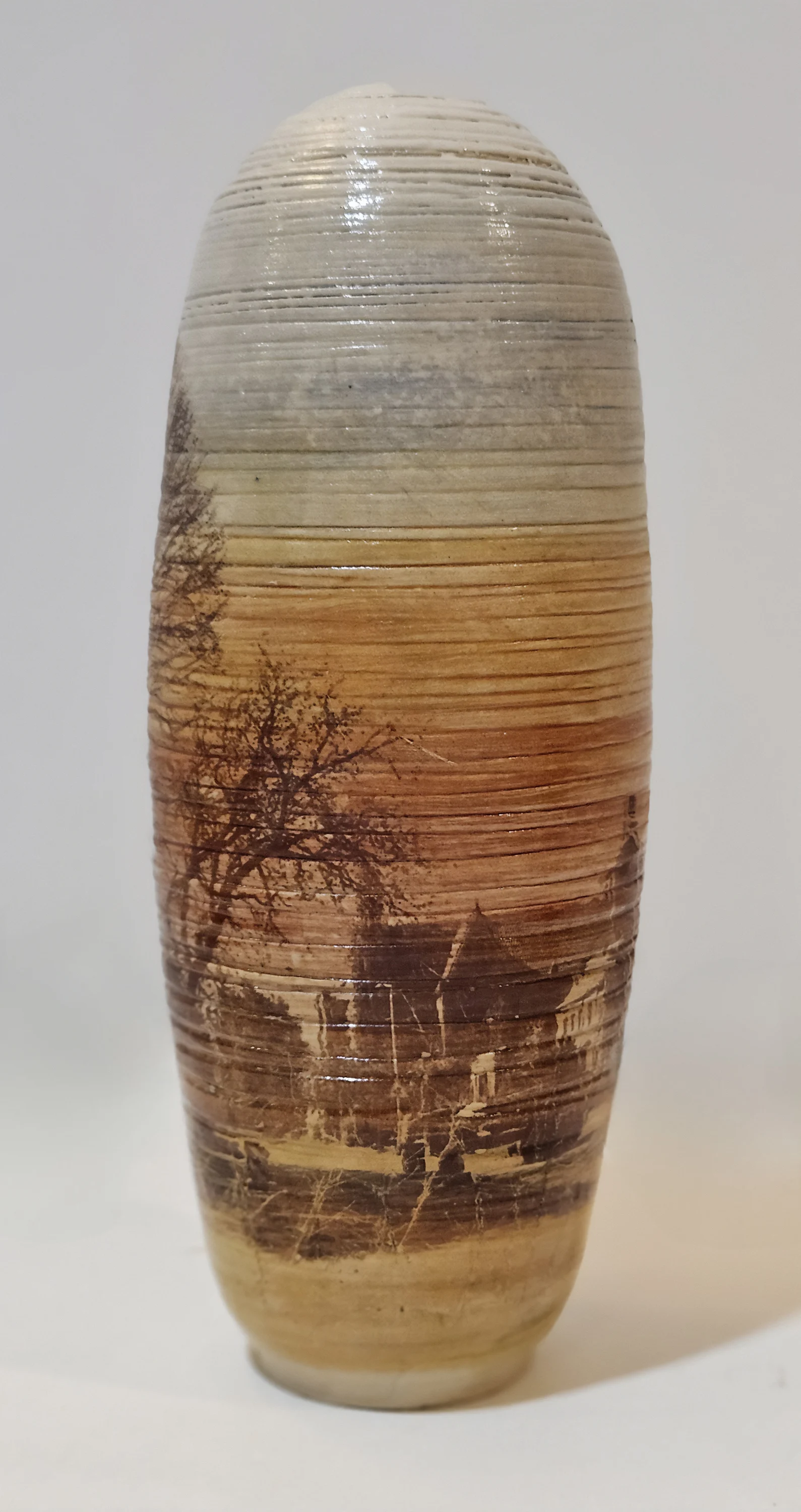 "Eve doğru 2" eseri OLGU SÜMENGEN BERKER tarafından 2024 yılında 9x9x22 cm ölçülerinde Stoneware çamur, tornada şekillendirme, 1220 °C pişirim, sıraltı boyalar, şeffaf sır decal baskı tekniği ile yapılmıştır.